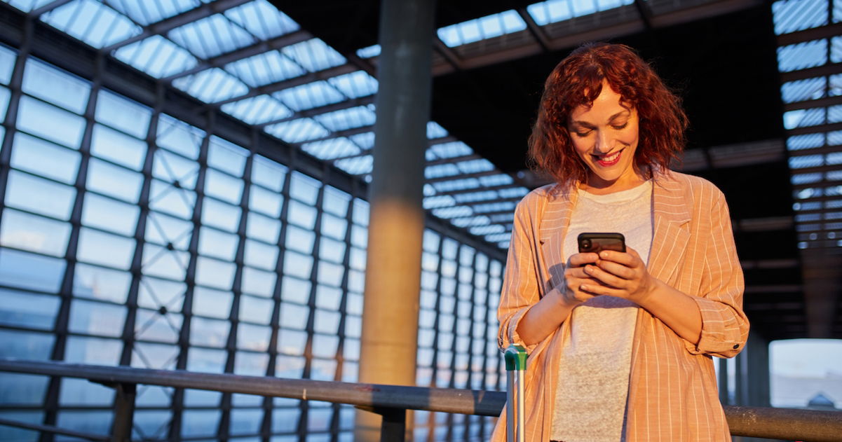 Mujer utilizando un teléfono móvil en un aeropuerto