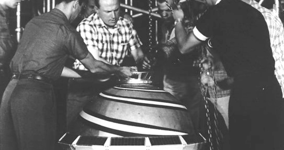 Workers manipulating the first navigation satellite