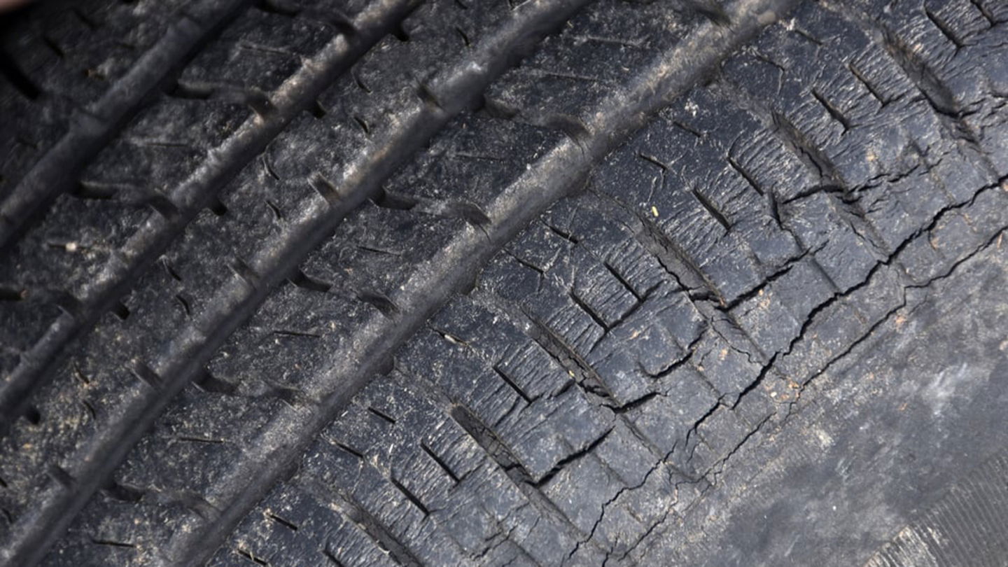 Detalle de un neumático con surcos longitudinales fruto de la pérdida de flexibilidad de la goma
