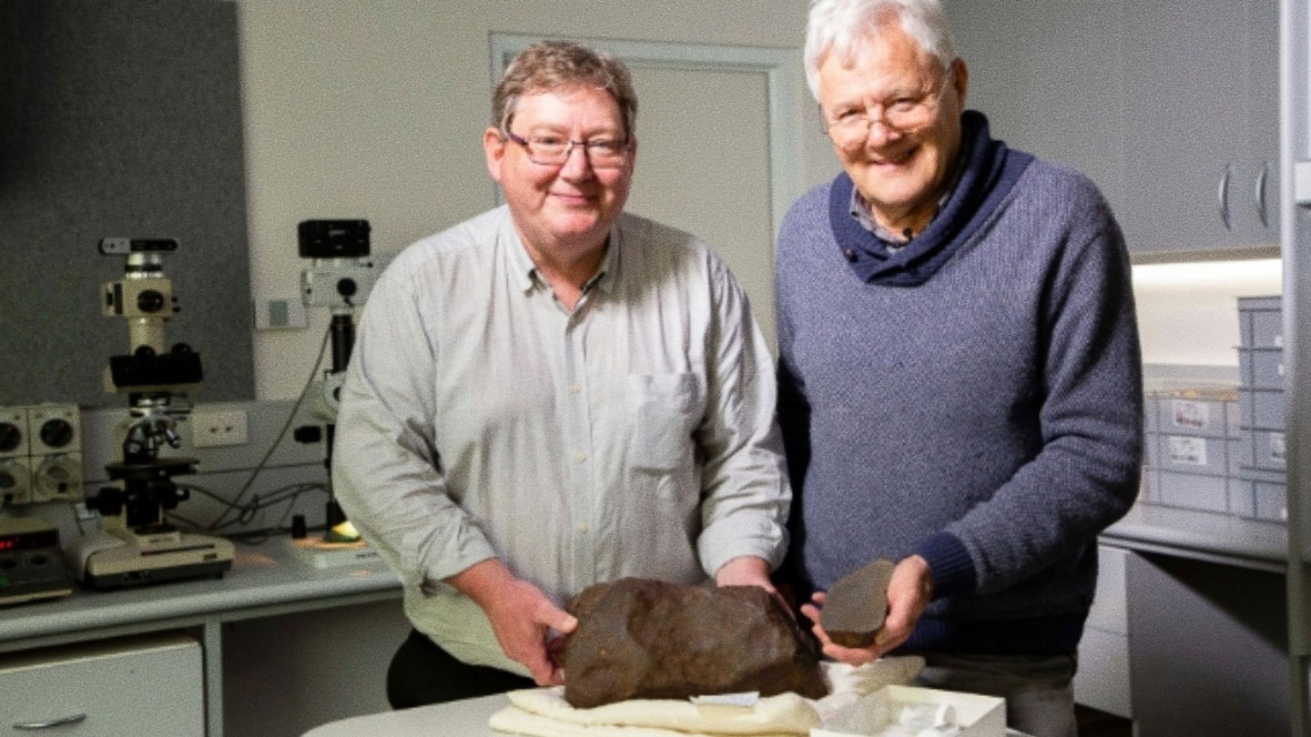 Dermot Henry y Bill Birch, geólogo del Museo de Melbourne, posando con el meteorito Maryborough