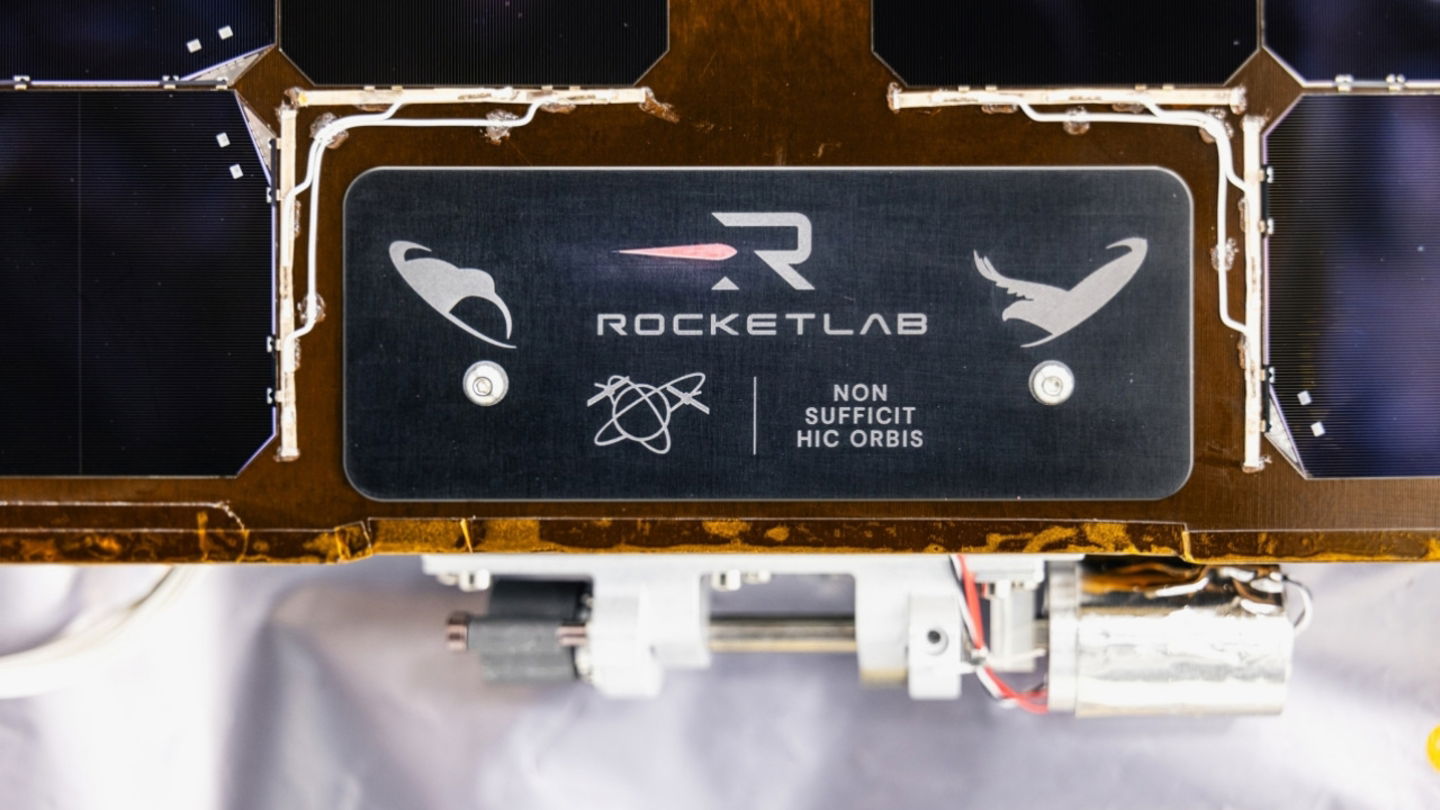 Detalle de la placa donde aparece el logotipo de Rocket Lab y las siluetas del águila y el kiwi
